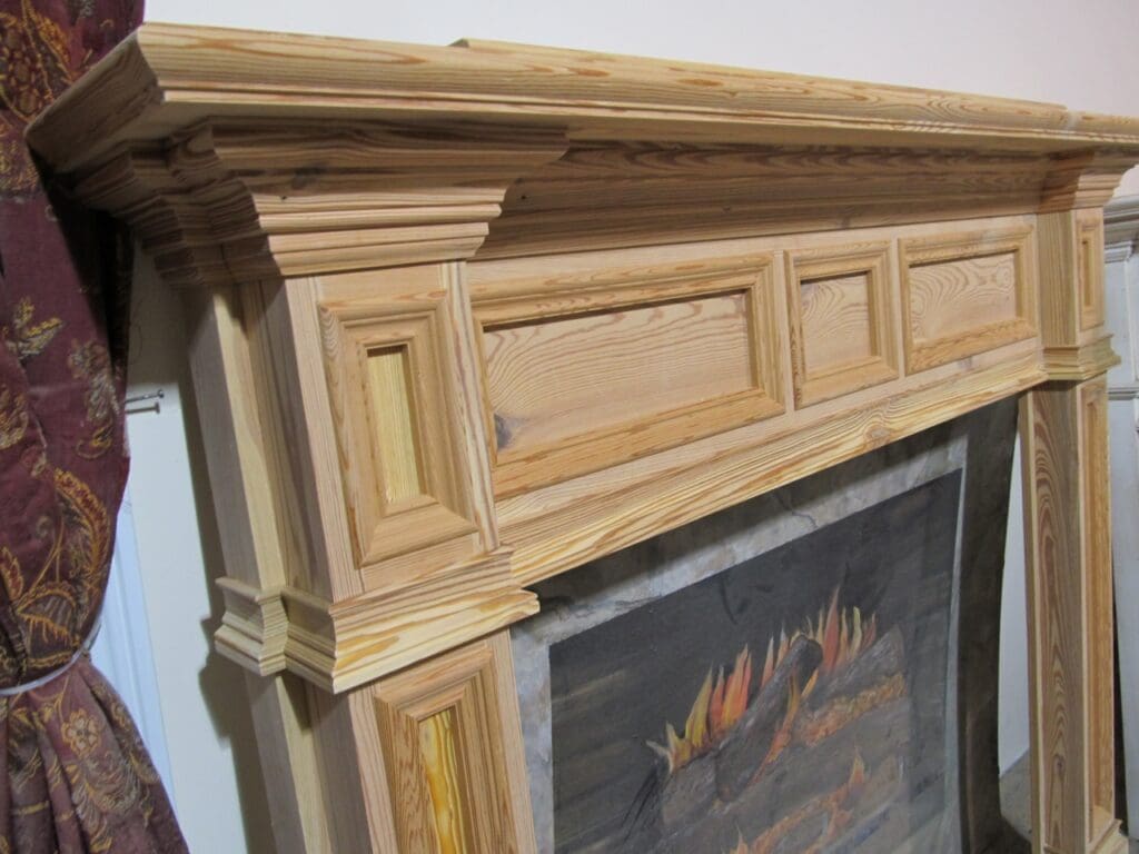 A fireplace mantle with wood trim and painting.