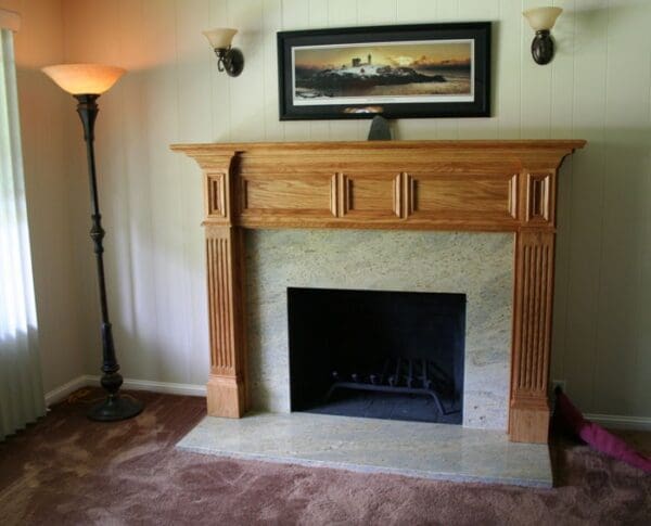 A fireplace with a picture hanging above it.