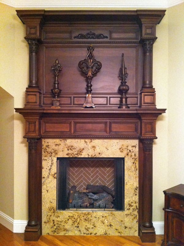 A fireplace with a wooden mantle and marble surround.