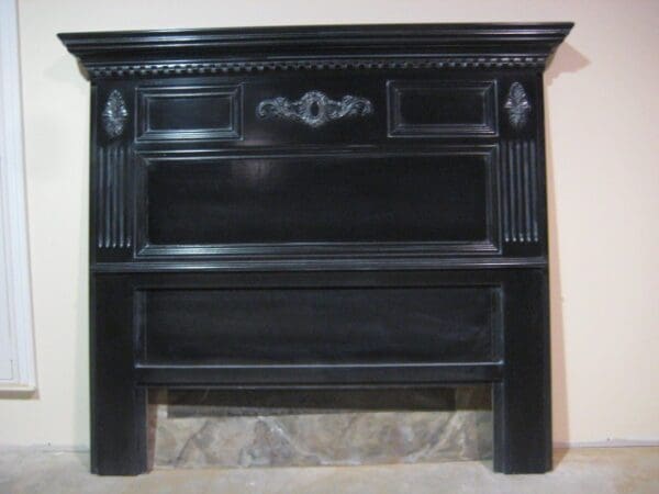 A black headboard with an ornate design on the top.