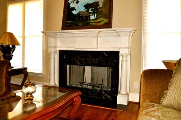 A fireplace in the corner of a living room.