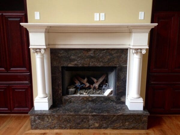 A fireplace with marble surround and white mantel.