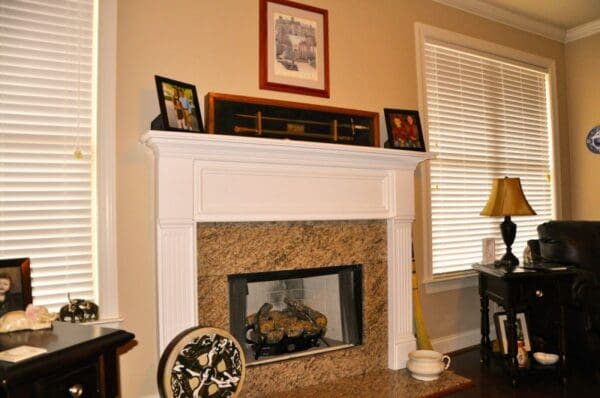 A fireplace with a clock and picture above it.