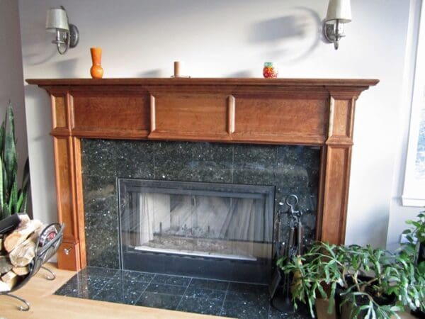 A fireplace with wood mantle and marble surround.