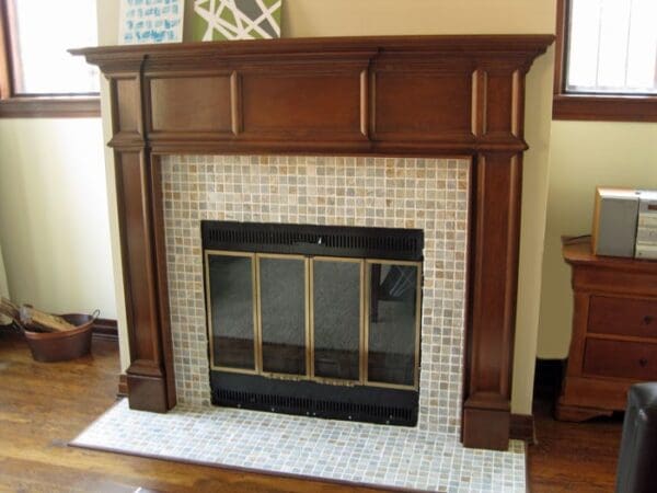 A fireplace with tile surround and wood mantle.