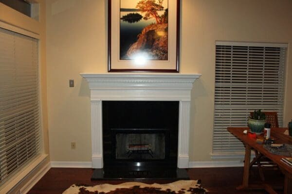 A fireplace with a picture hanging above it.