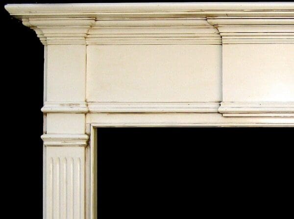 A white fireplace mantle with black background