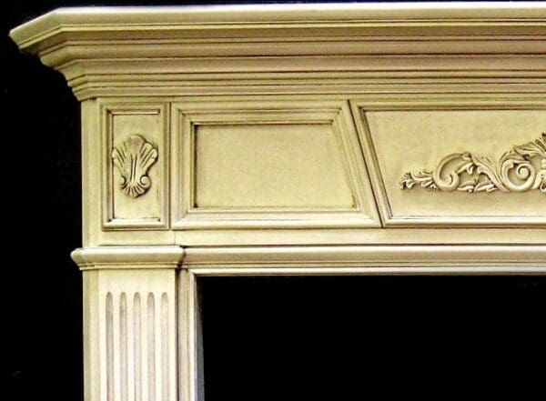 A fireplace mantle with a white painted finish.