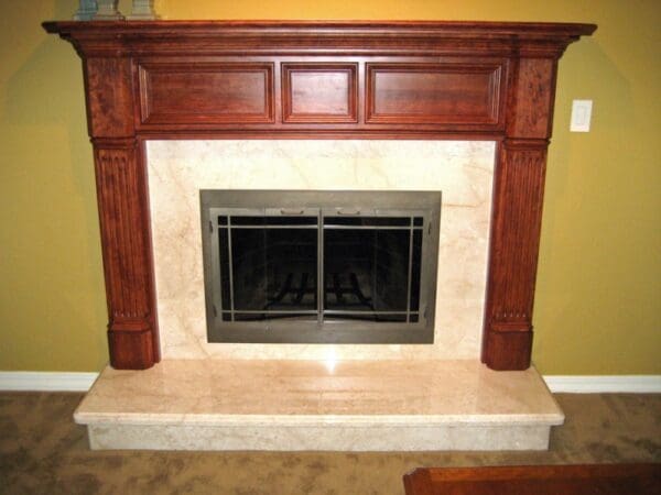 A fireplace with wood mantle and marble surround.