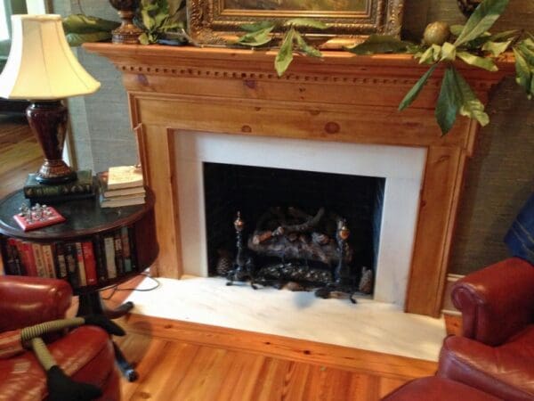 A fireplace with wood mantle and white tile surround.