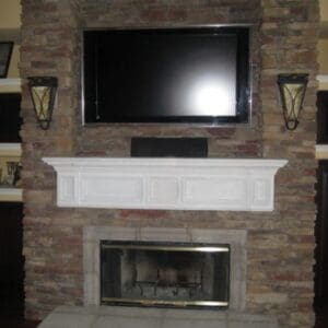 A fireplace with a flat screen tv mounted above it.