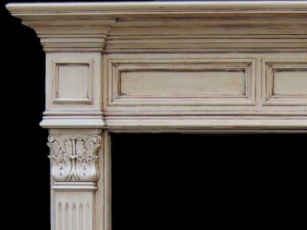 A fireplace mantle with a carved panel and corbels.