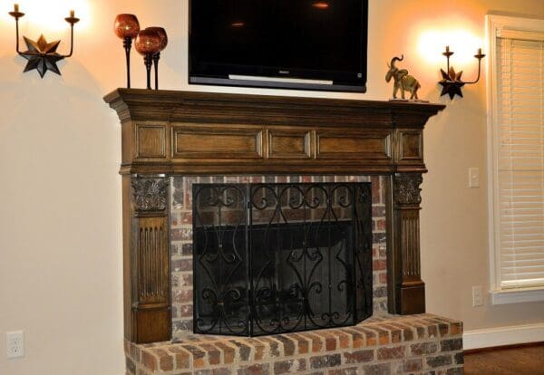 A fireplace with a television above it and two lamps on the wall.