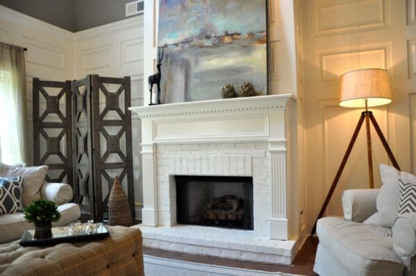 A fireplace with a painting above it in the living room.