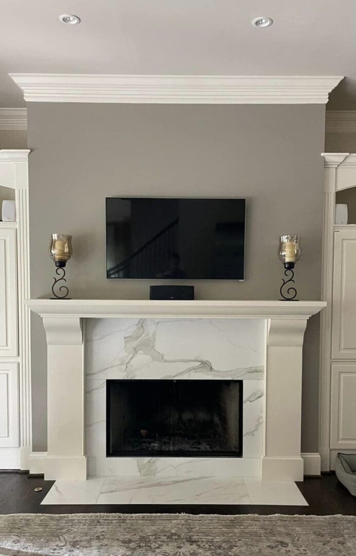 White marble fireplace with TV above.