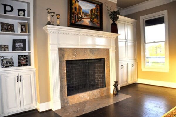 White fireplace with stone surround and hearth.