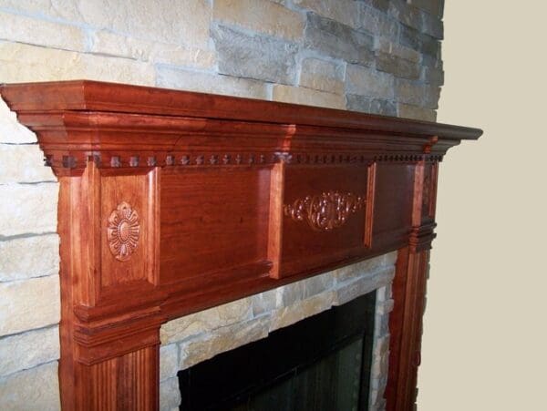 Ornate wooden fireplace mantel with stone surround.