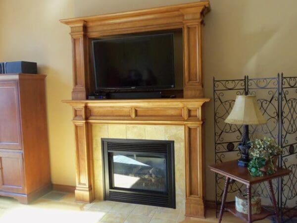 Wooden fireplace with built-in TV.