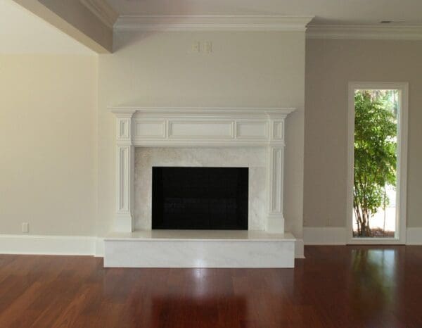 White fireplace with black insert in room.