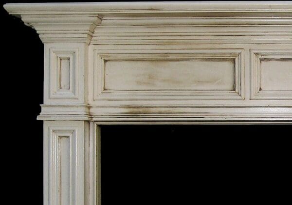 White painted fireplace mantel with molding.