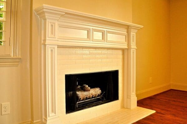 White fireplace with tile surround.