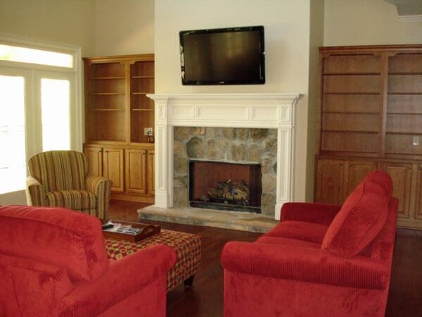 Living room with fireplace and red sofas.