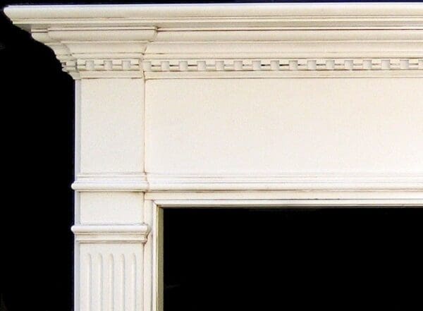 White painted fireplace mantel with molding.