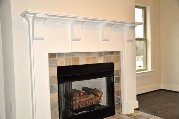 White fireplace mantel with tiled surround.