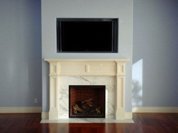 White marble fireplace with black TV above.