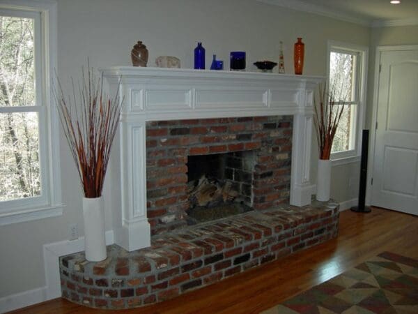 Brick fireplace with white mantel and hearth.