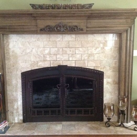 A fireplace with a stone surround and two doors.