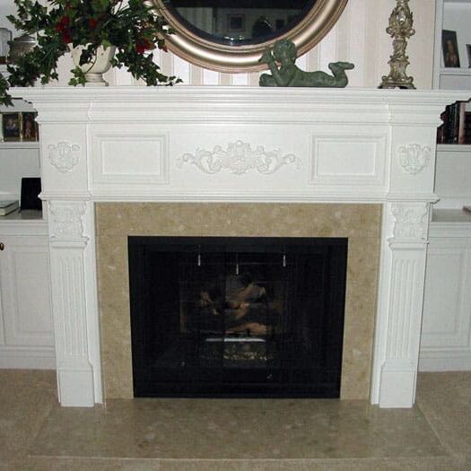 A fireplace with a mantle and surround in the center.