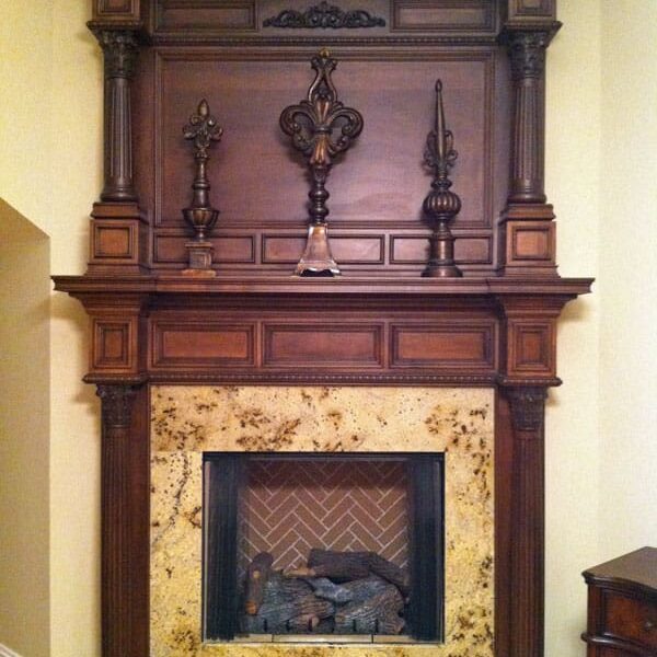 A fireplace with a wooden mantle and marble surround.